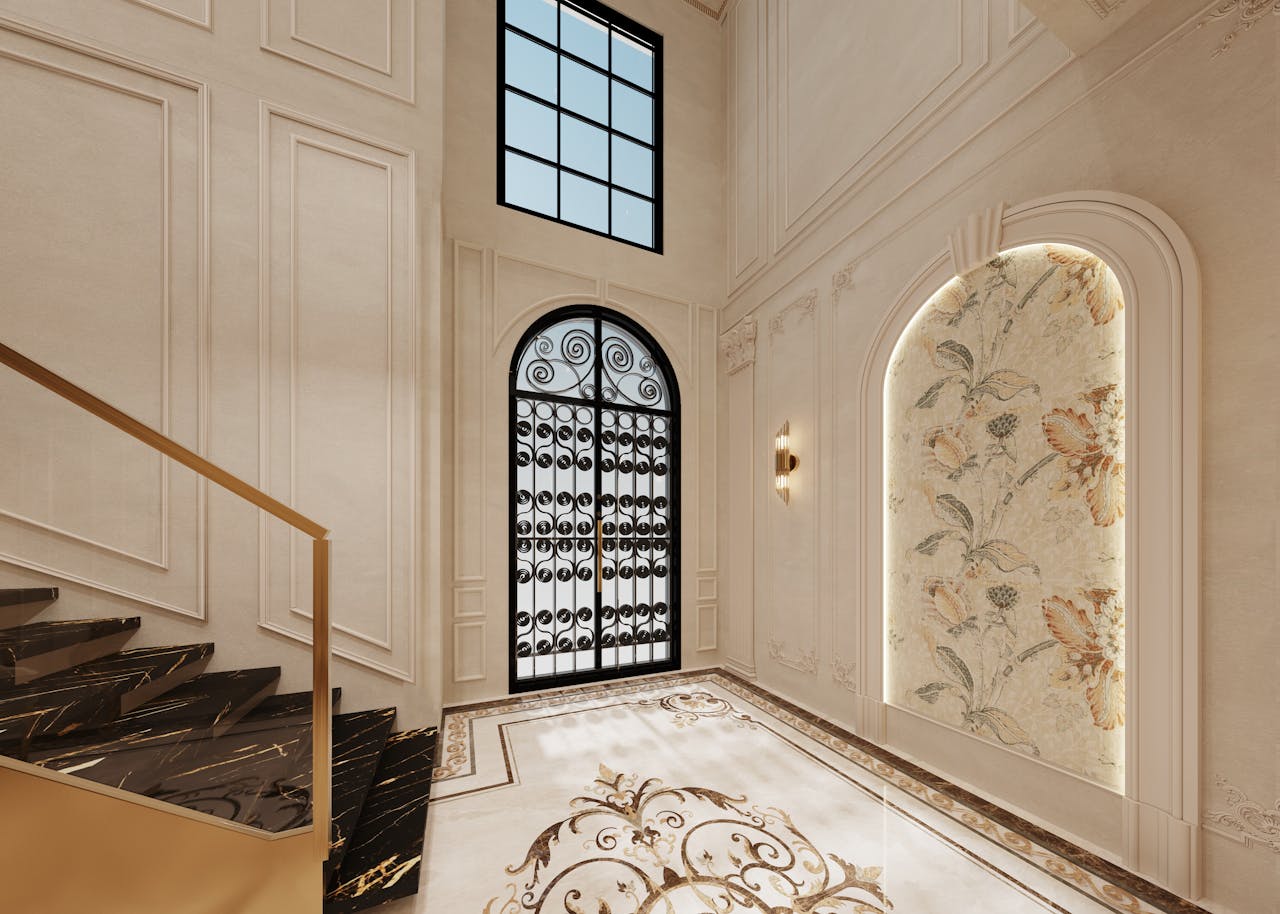 Luxurious home entryway with wrought iron door and ornate staircase