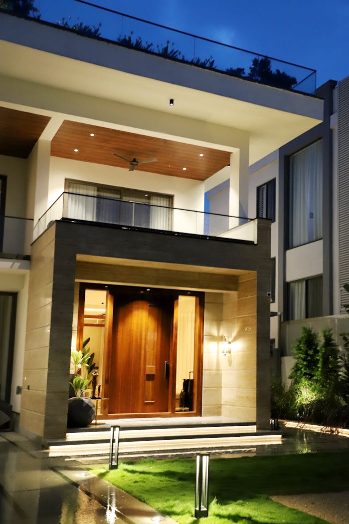 Elegant entrance of a modern luxury home illuminated at night with stylish architecture.